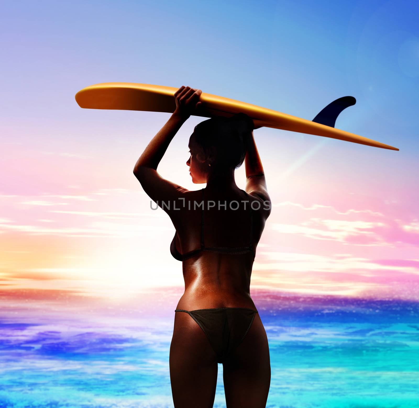 sexy surfer with surfboard on the beach at sunrise