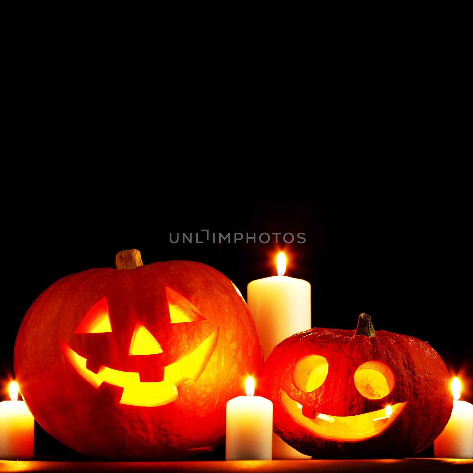 Halloween pumpkins and candles isolated on black background