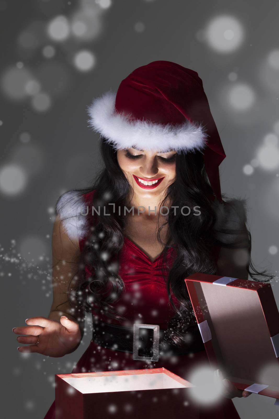 Beautiful Santa girl opening the magical Christmas present box