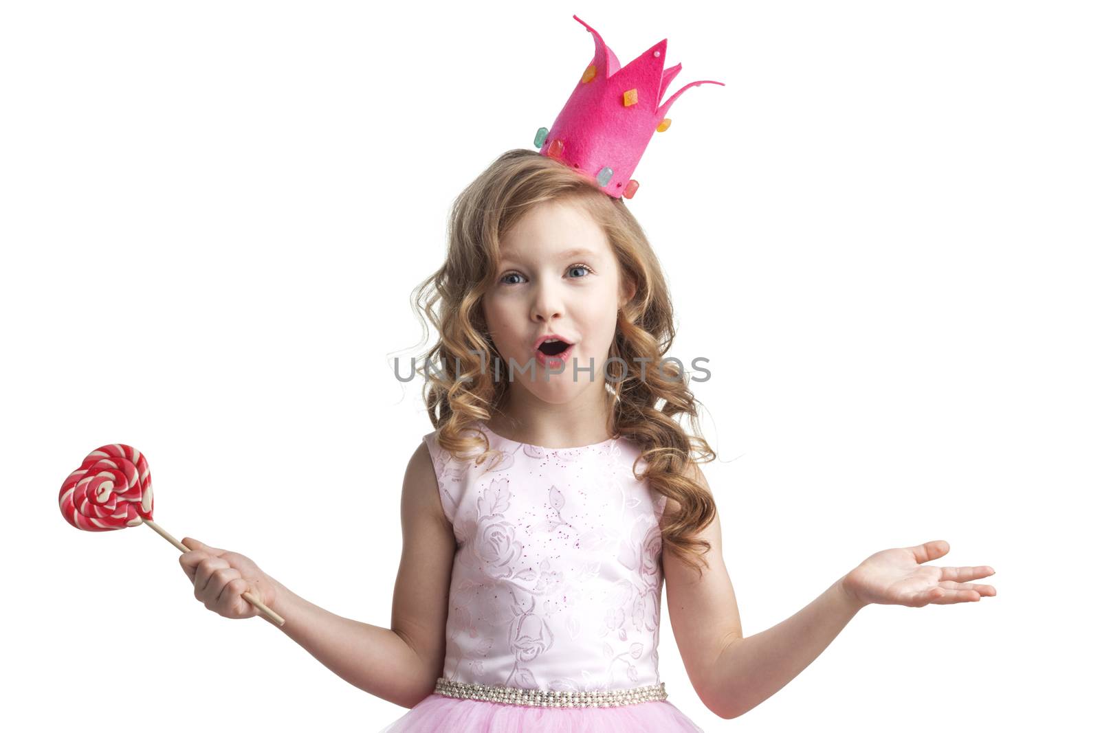Beautiful little candy princess girl in crown holding big pink heart lollipop and smiling
