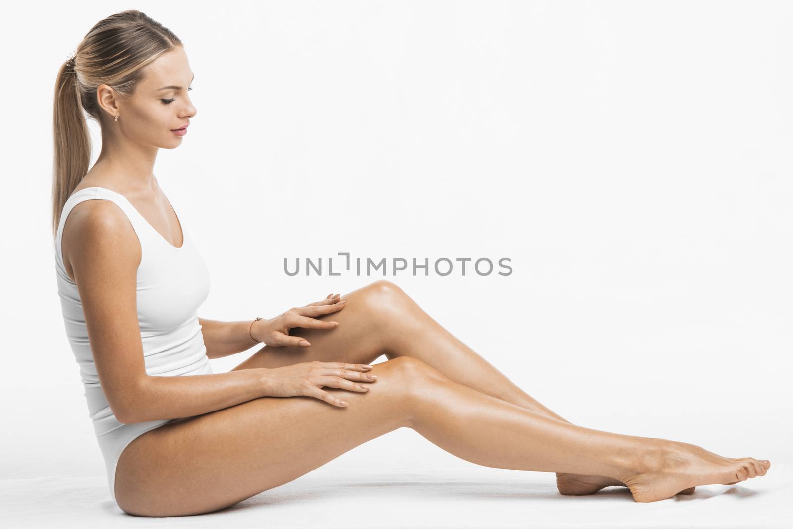 Young beautiful woman in white cotton underwear sitting isolated on white background