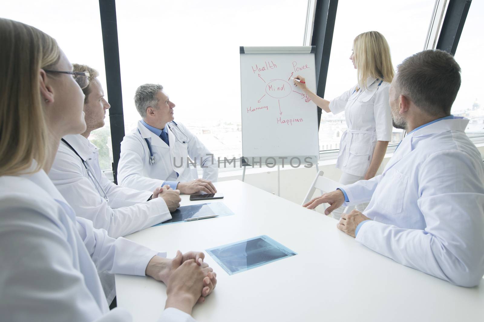 Team of doctors listening mental health conceptual presentation in clinical office and applauding