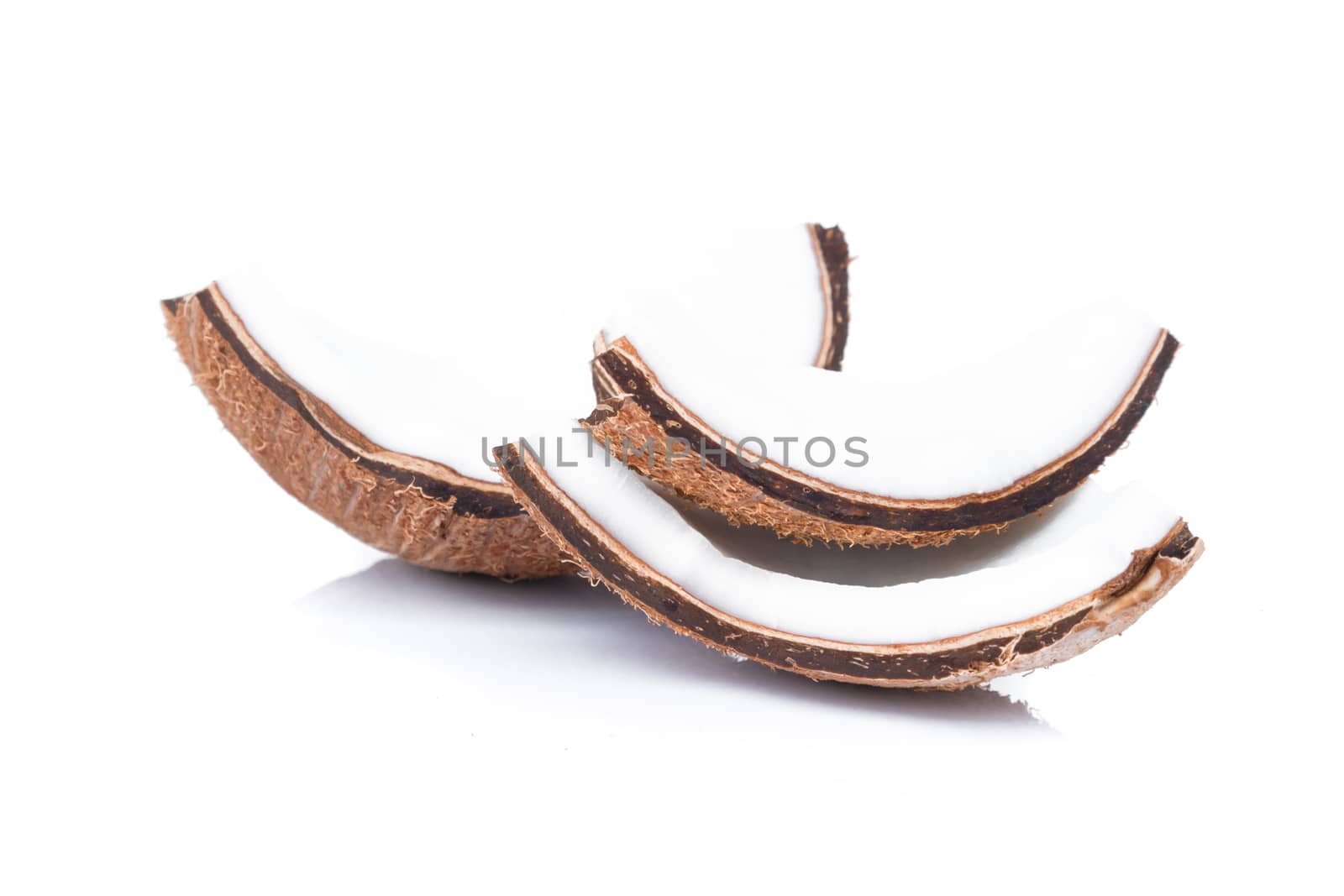 Pieces of coconut shell broken into pieces and stacked on white background