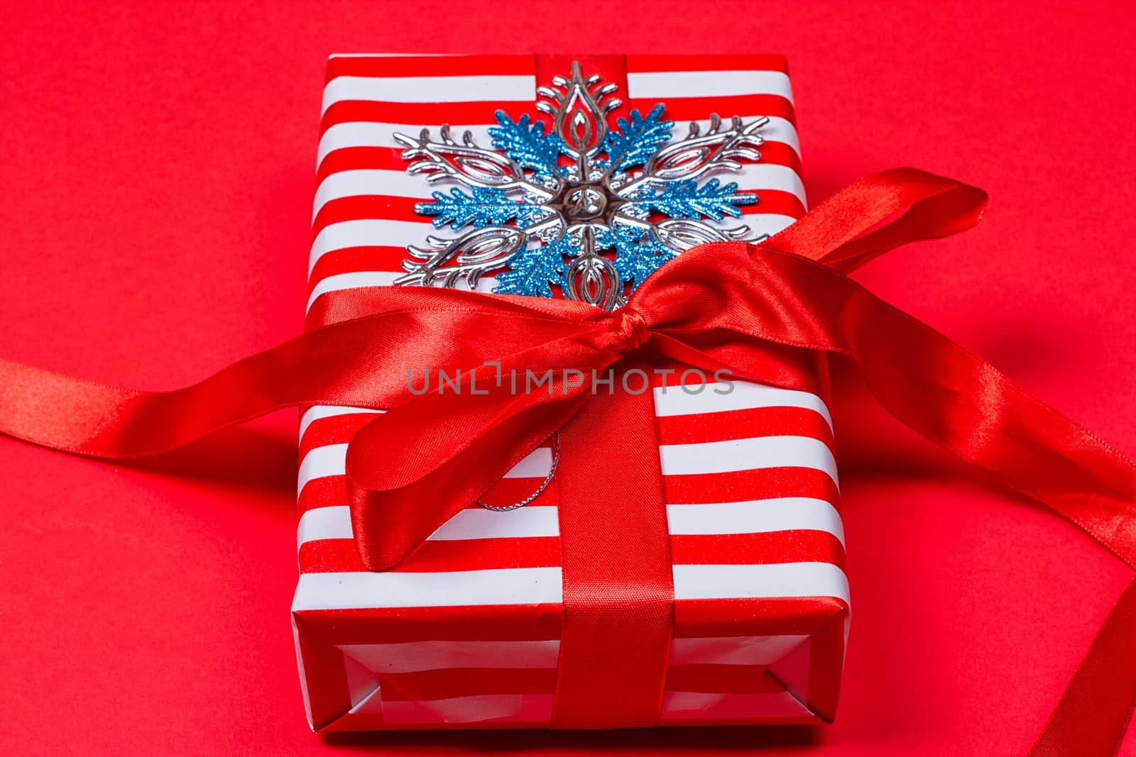 Christmas gift, toy, Snowflakes in the foreground. red background