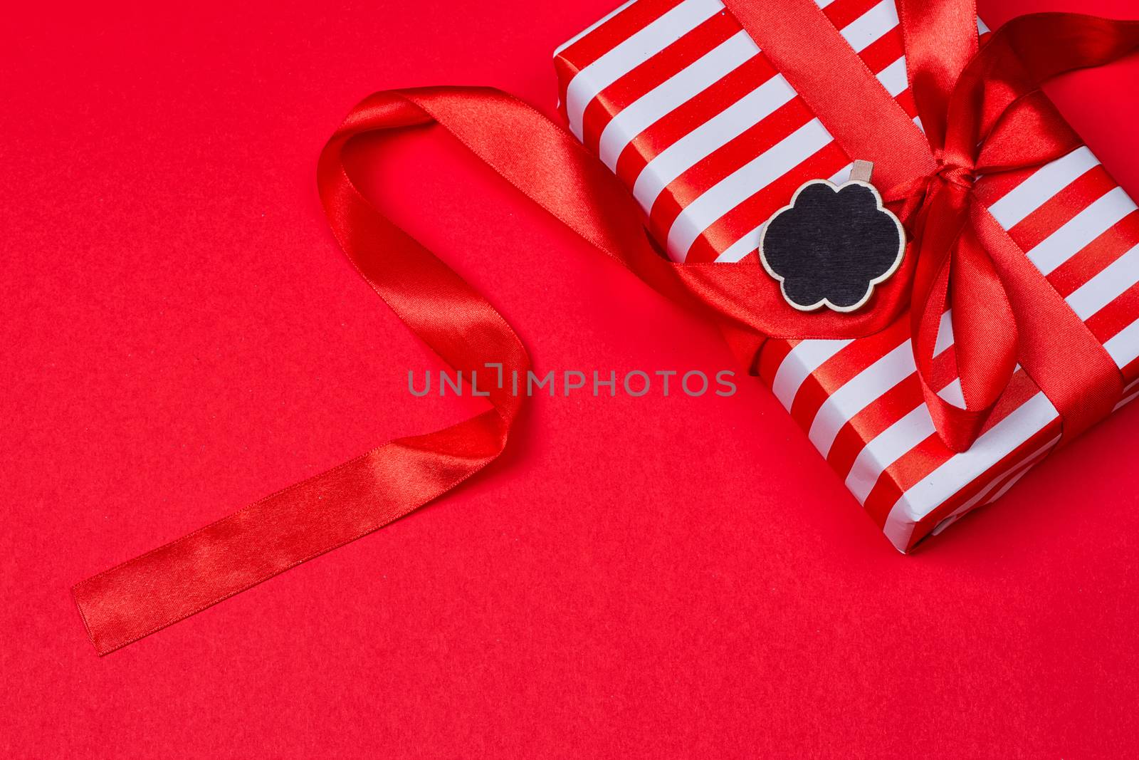 gift with red bow on red background. Free space for your text.