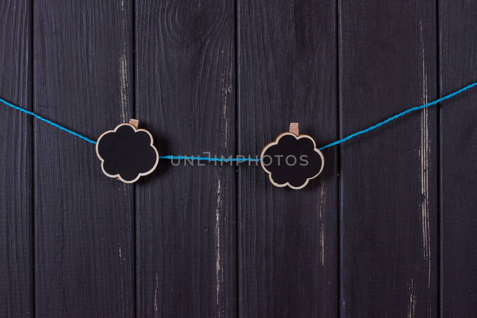 Clothespins with space for text on a black wooden fence