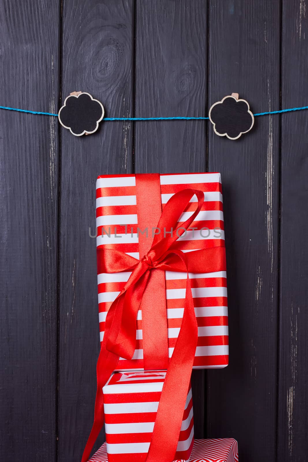 Gift box with a red bow on a wooden background With clothes pegs and place for text