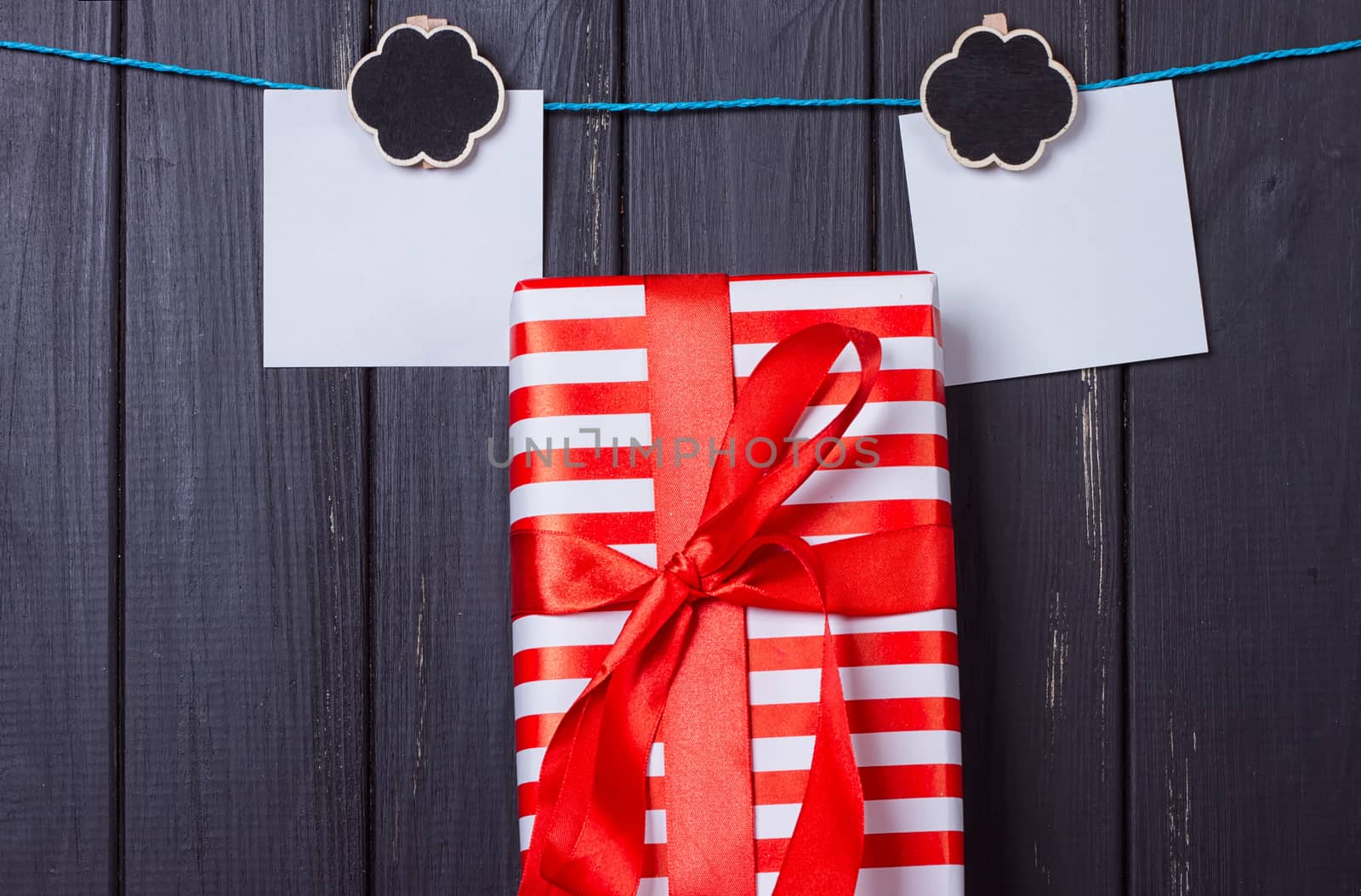 Gift box with a red bow on a wooden background by victosha