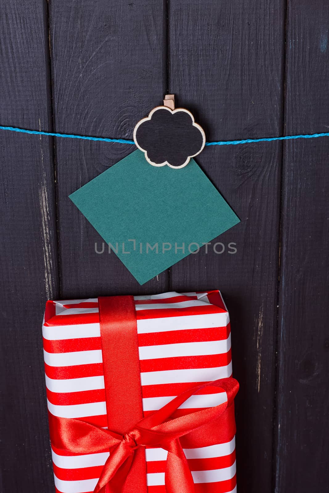 Gift box with a red bow on a wooden background by victosha