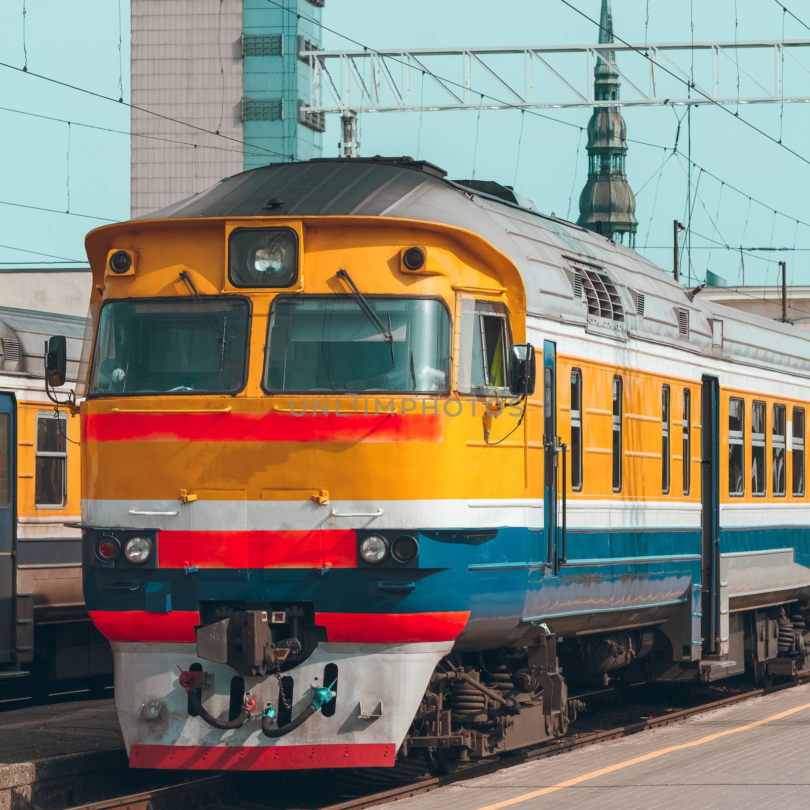 Old yellow passenger diesel train moving at the terminal