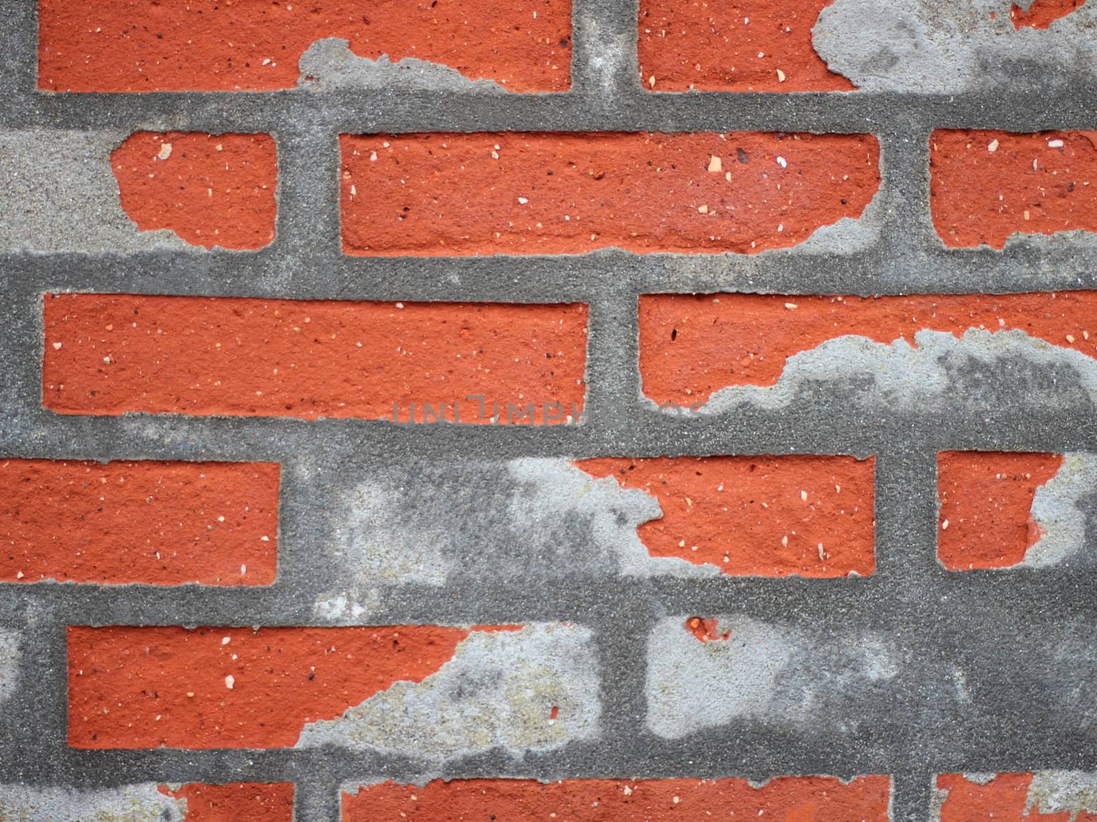 Red Worn Repaired Brickwall with Uneven Mortar Closeup