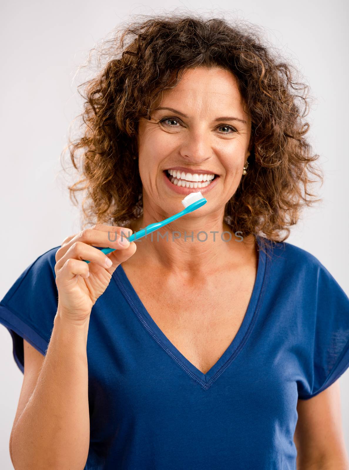 Beautiful mature woman brushing her teeths 