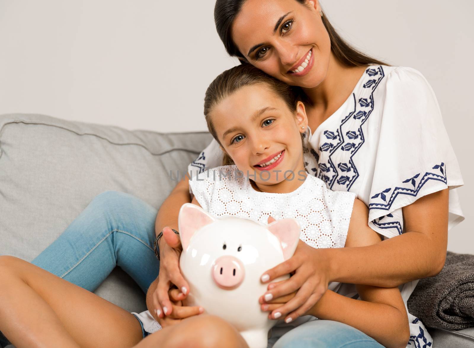 Mother and daughter with a piggy bank for her future savings