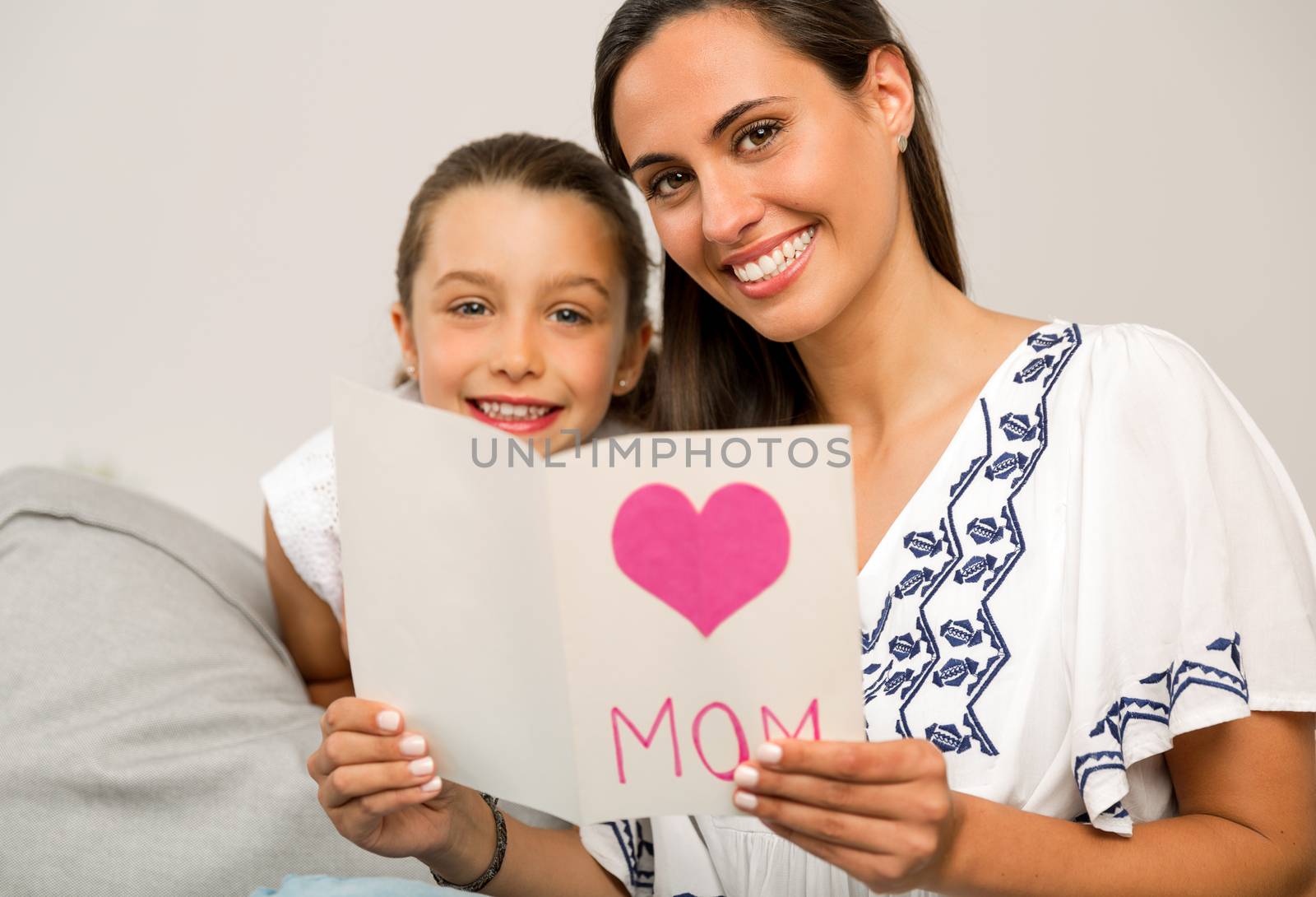 Mother receiving a greeting card on mother's day from her daughter