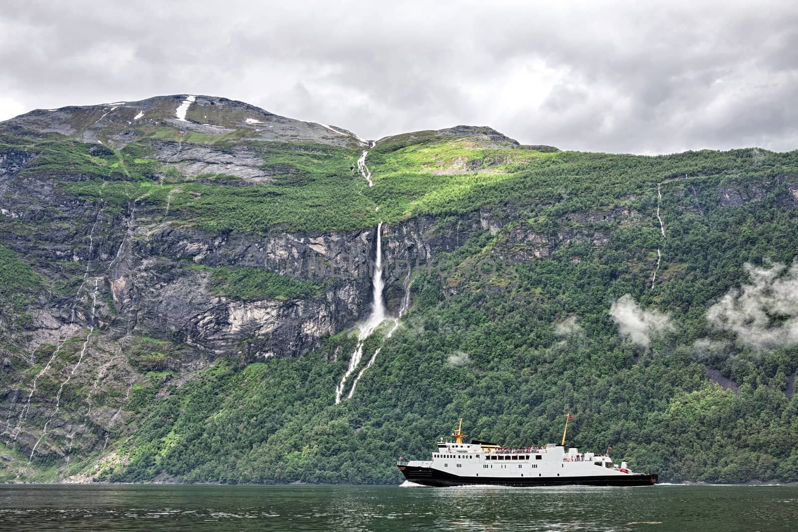 Cruise ship sailing in Geiranger in a cloudy day, Norway