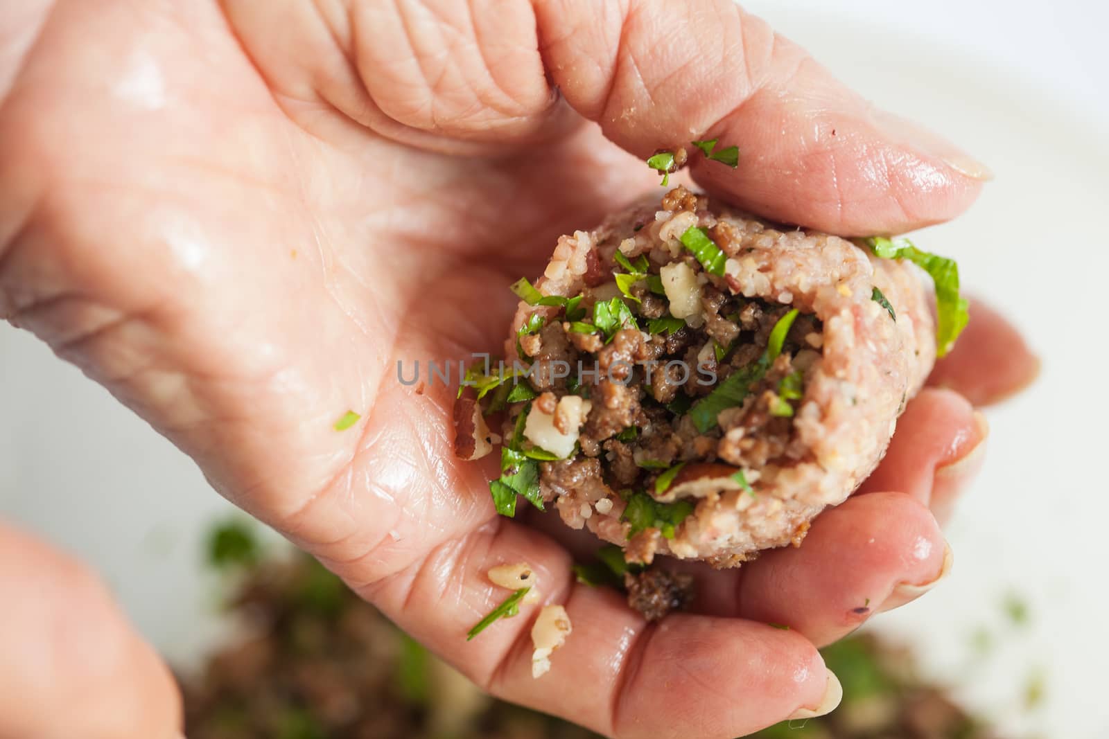 Step by step Levantine cuisine kibbeh preparation : Close up of a senior woman hands filling a kibbeh