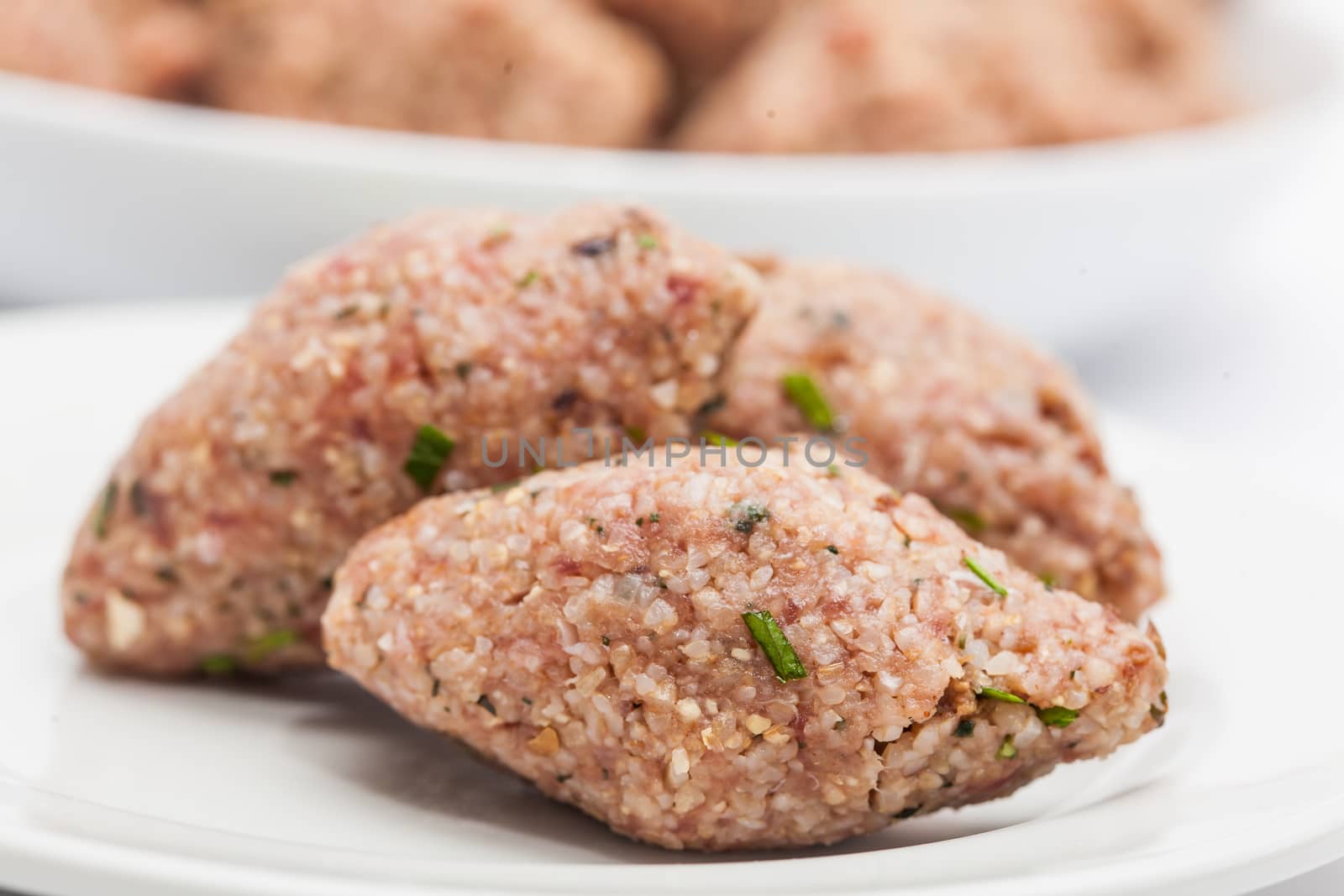 Step by step Levantine cuisine kibbeh preparation : Raw kibbeh balls on white dish