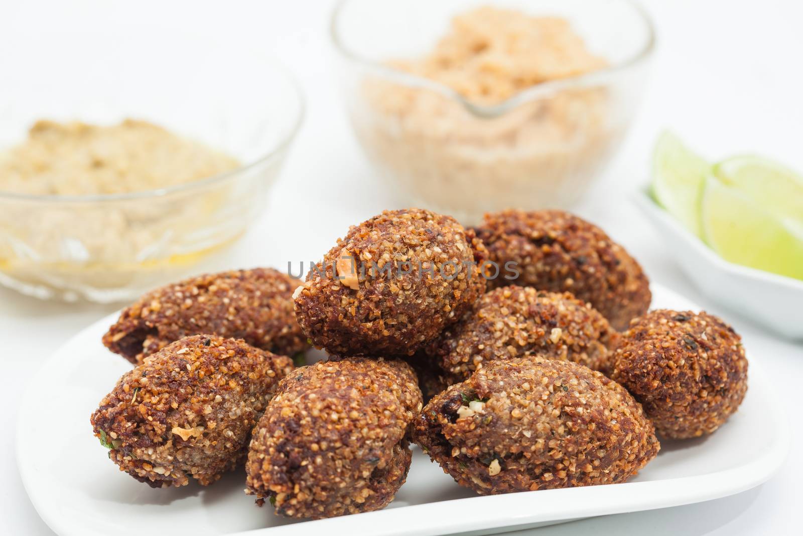 Step by step Levantine cuisine kibbeh preparation : Ready fried kibbeh served with tahini and hummus