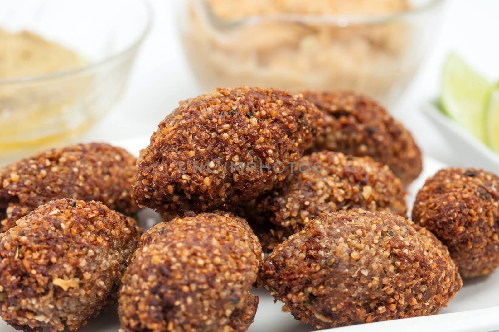 Step by step Levantine cuisine kibbeh preparation : Ready fried kibbeh served with tahini and hummus