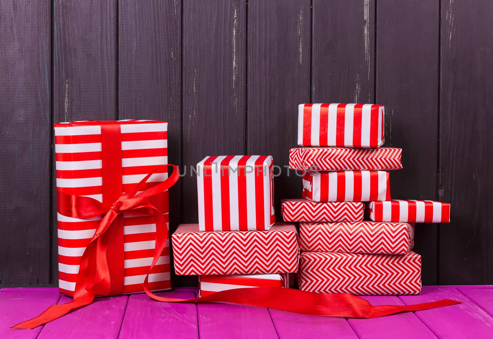 Gift boxes with ribbons and christmas decor on wooden background