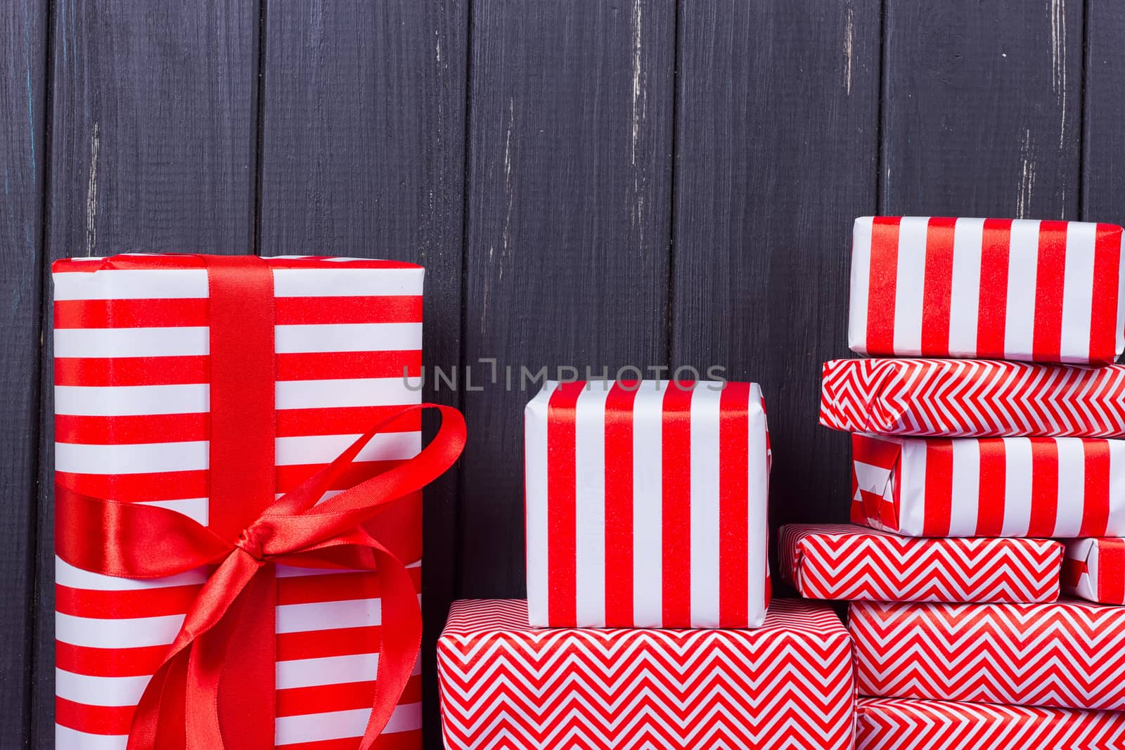 Gift boxes with ribbons and christmas decor on wooden background