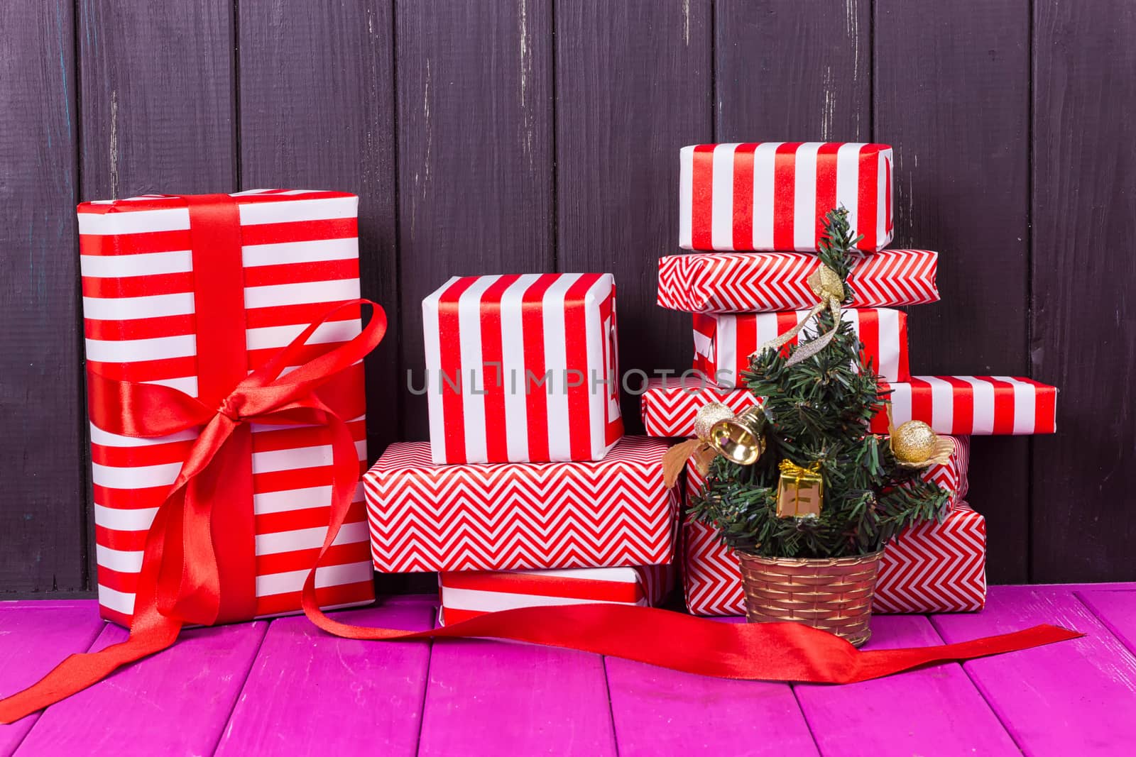 Gift boxes and small decorated Christmas tree on black background