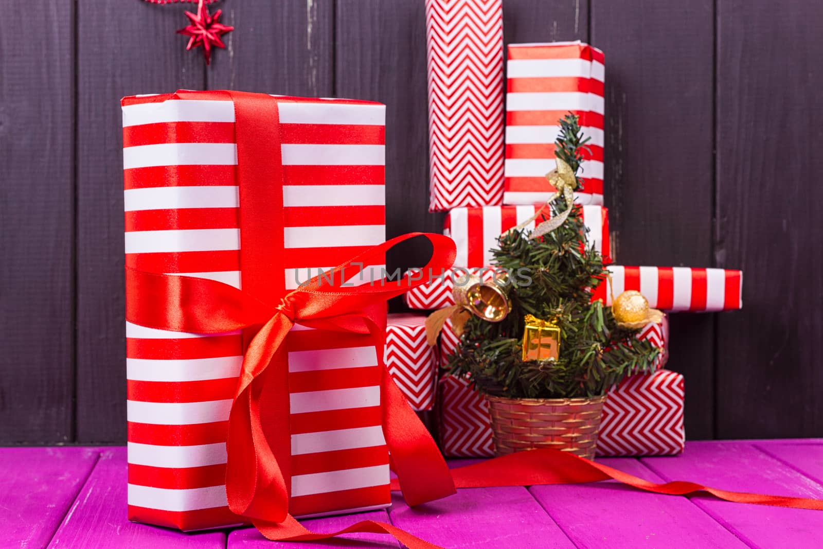 Gift boxes and small decorated Christmas tree on black background