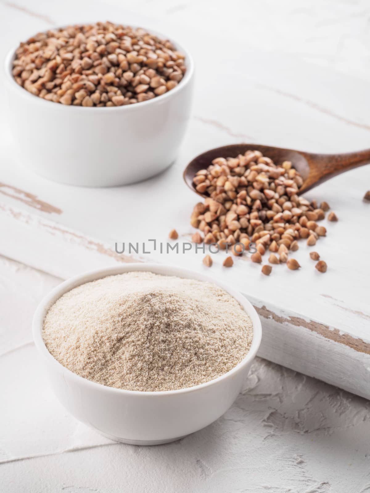 Buckwheat flour and buckwheat on white background