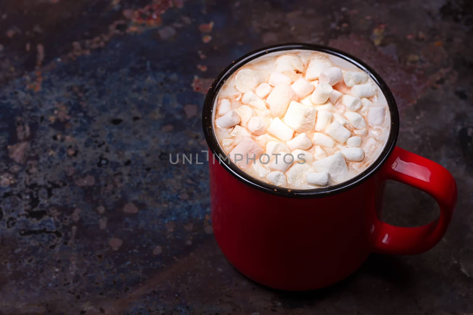 Hot chocolate with marshmallows on grunge dark table