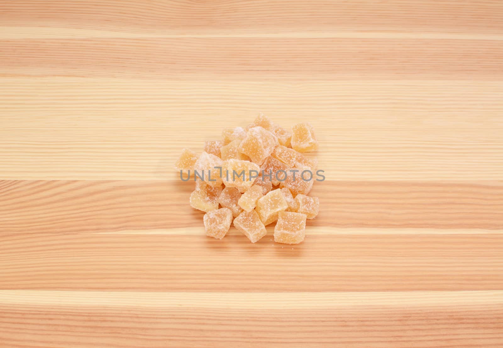 Cubes of crystallised stem ginger on a wooden background, pine wood grain