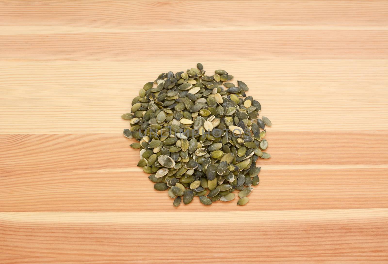 Pumpkin seeds on a wooden background, pine wood grain