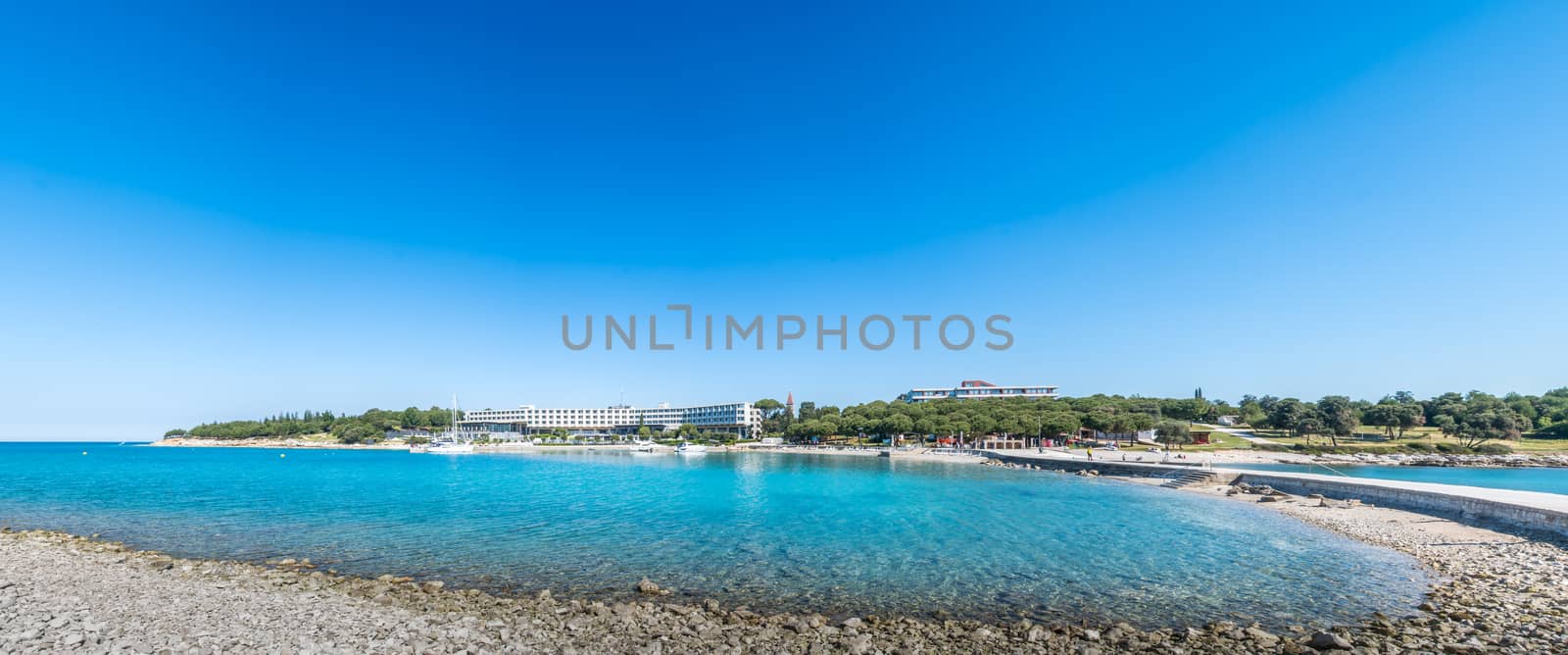 Seaside hotel with beach and turquoise water, Sveti Andrija or Red island near Rovinj, Croatia by asafaric