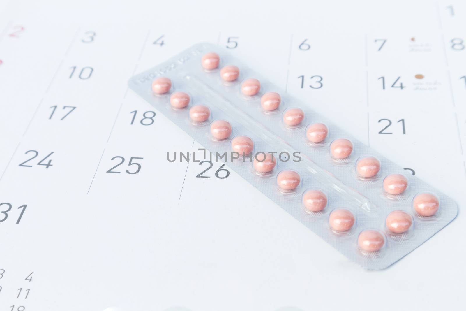 Close up birth-control pill with date of calendar background, health care and medicine concept