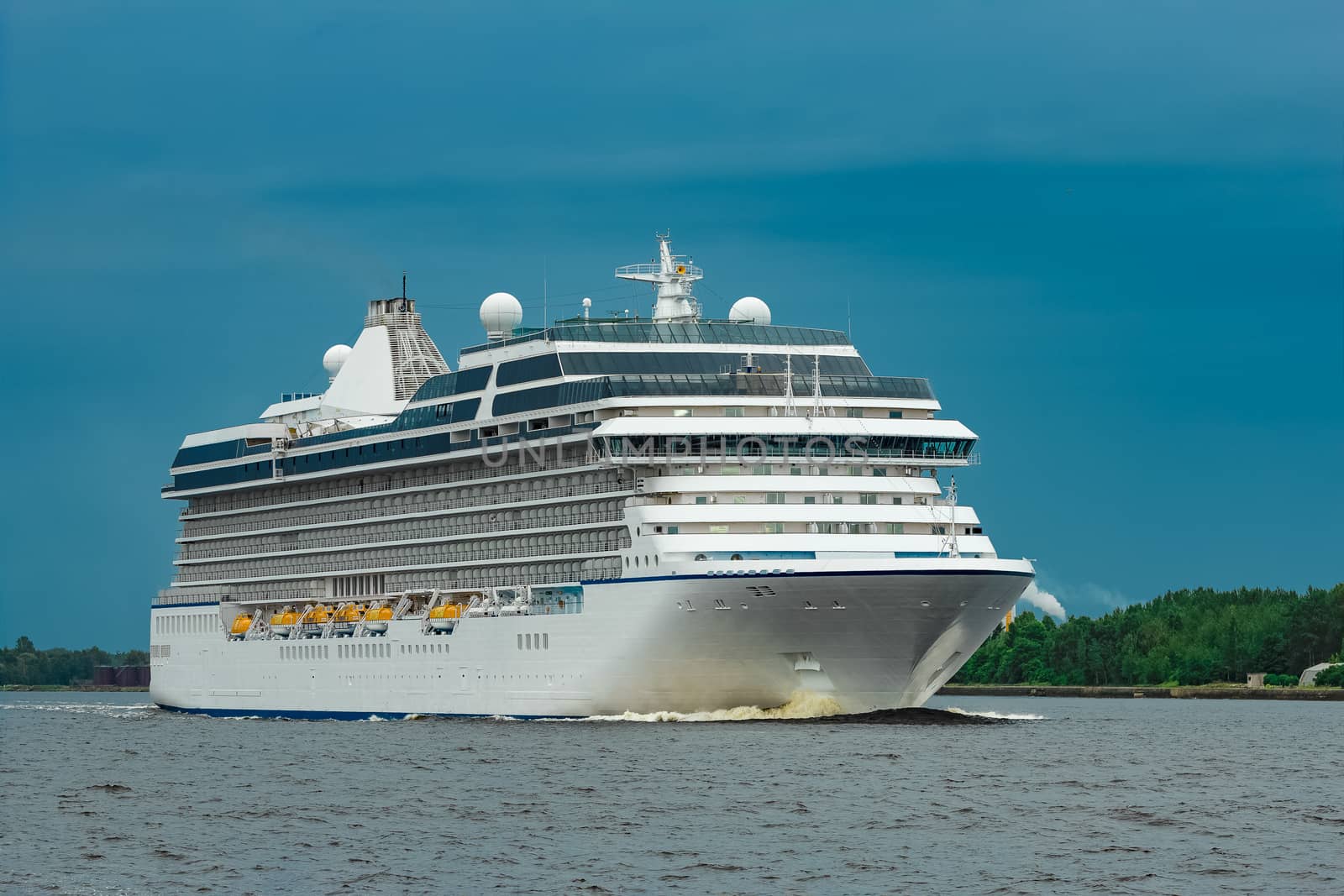 White cruise liner moving to the sea at cloudy day