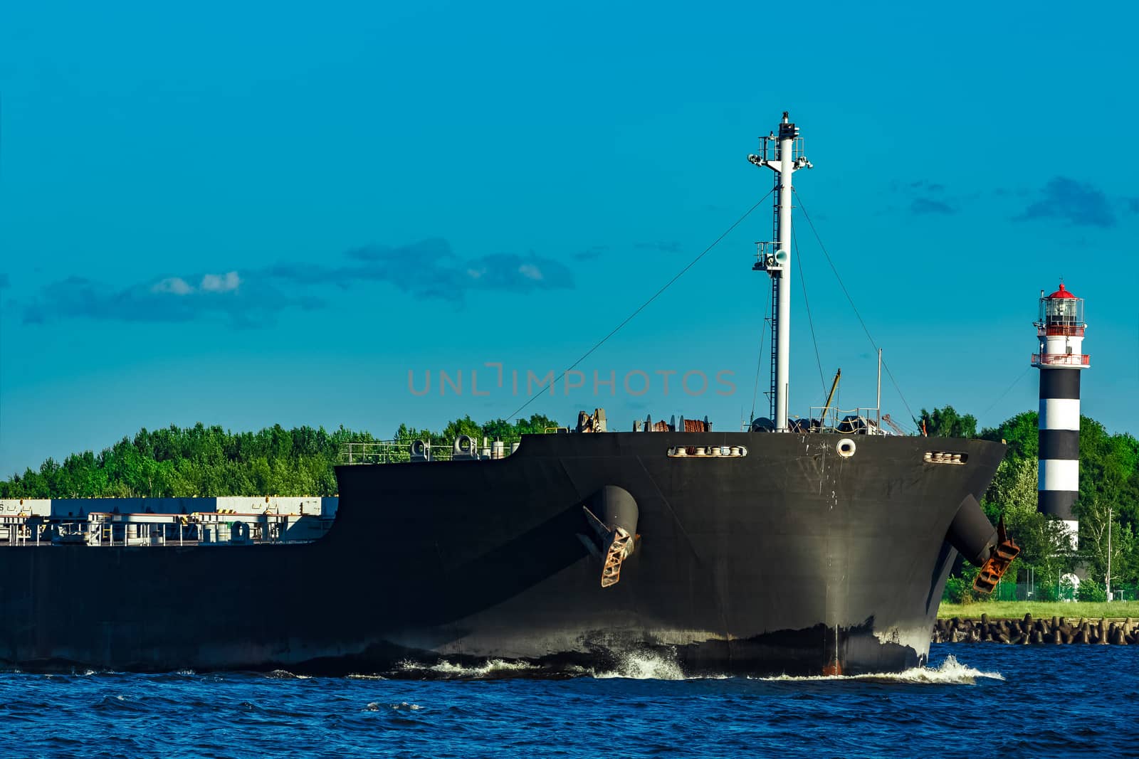 Black cargo ship moving to Baltic sea at clear day