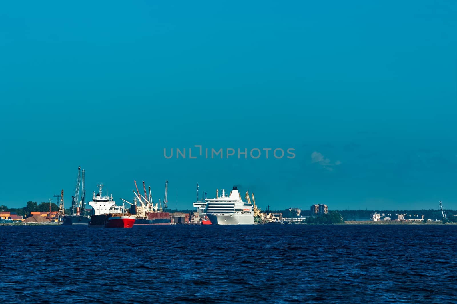 Red cargo ship fully loaded with wood moving at clear day