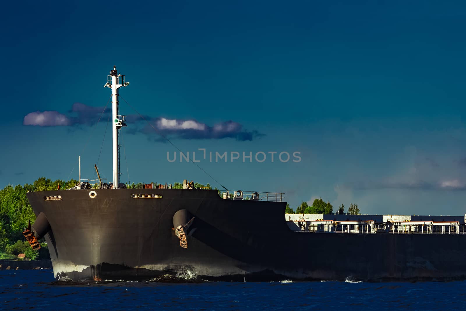 Black bulk carrier moving at evening to Baltic sea