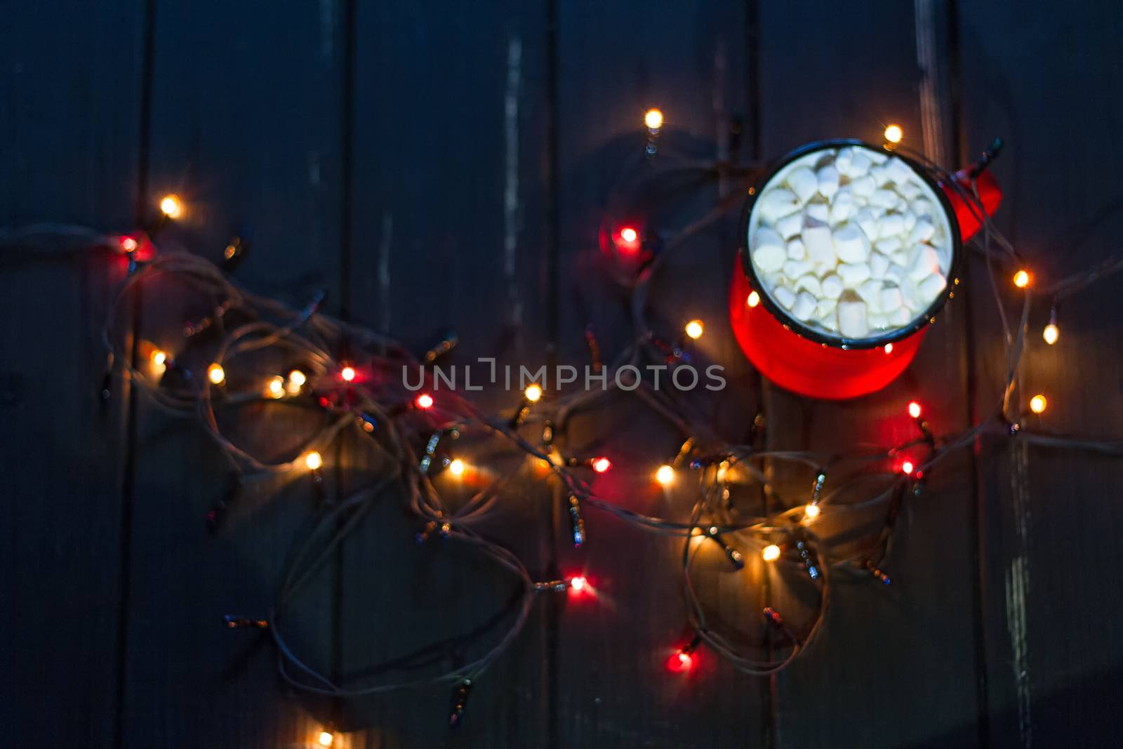 Decorative garland. Christmas lights on dark background and cup.