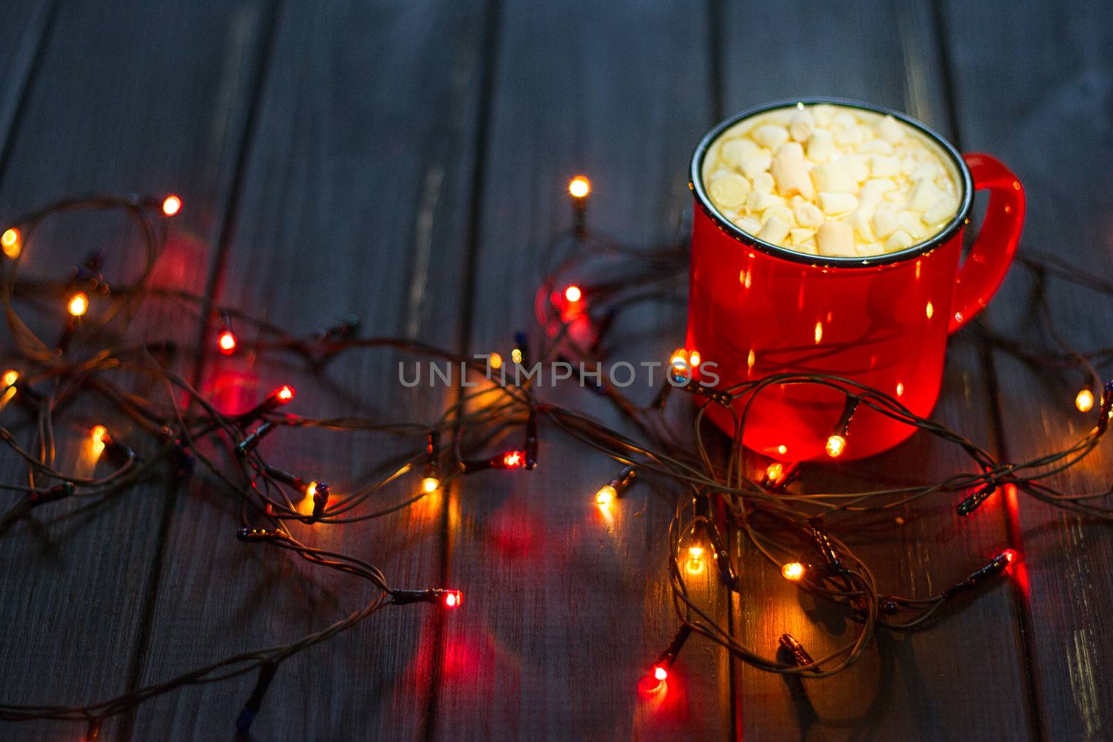 Decorative garland. Christmas lights on dark background and cup.