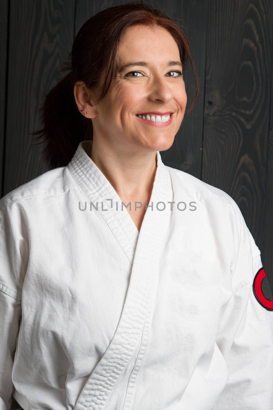 forty year old woman wearing karate gi with a great big smile