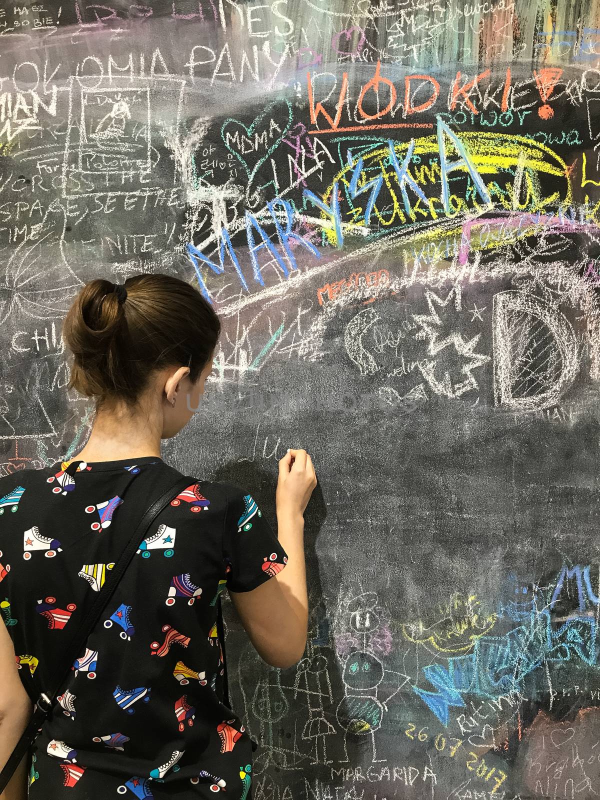 Back to school. A child paints scribbles by chalk on a board