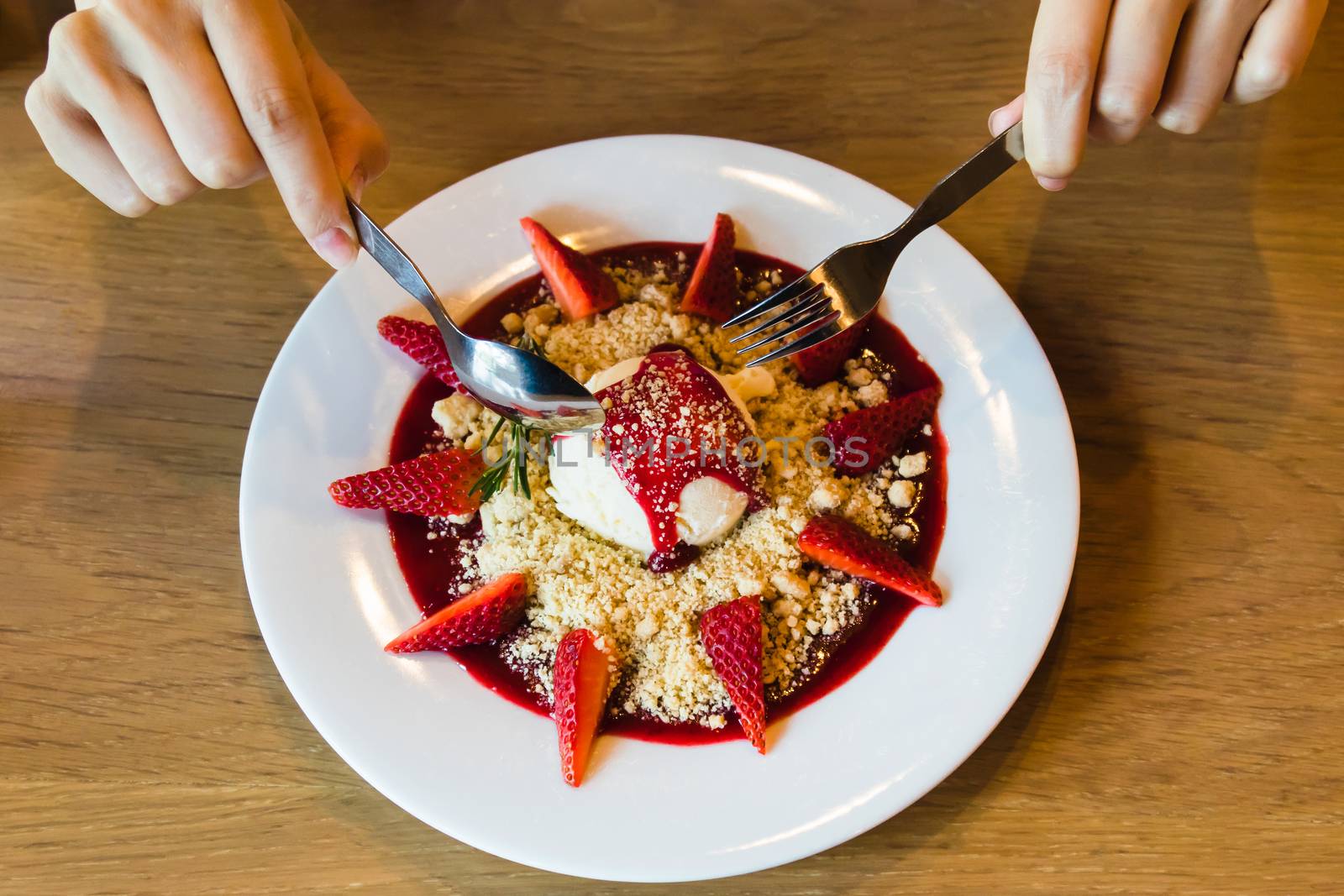 Ice cream with strawberry and cookie crumble on white dish