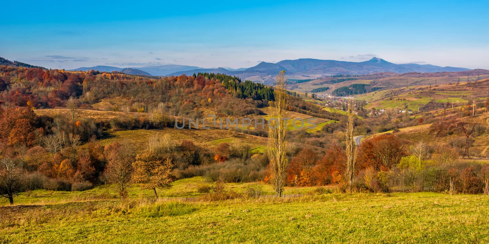rural grassy fields on hills in gorgeous mountains. stunning panorama of countryside landscape in autumn