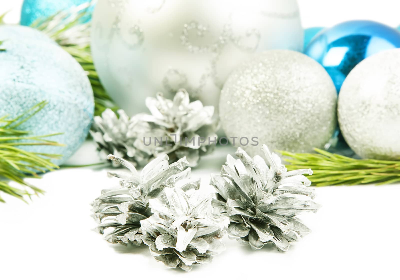 New year composition with fir tree branch, beautiful silver ball and silver cones close up
