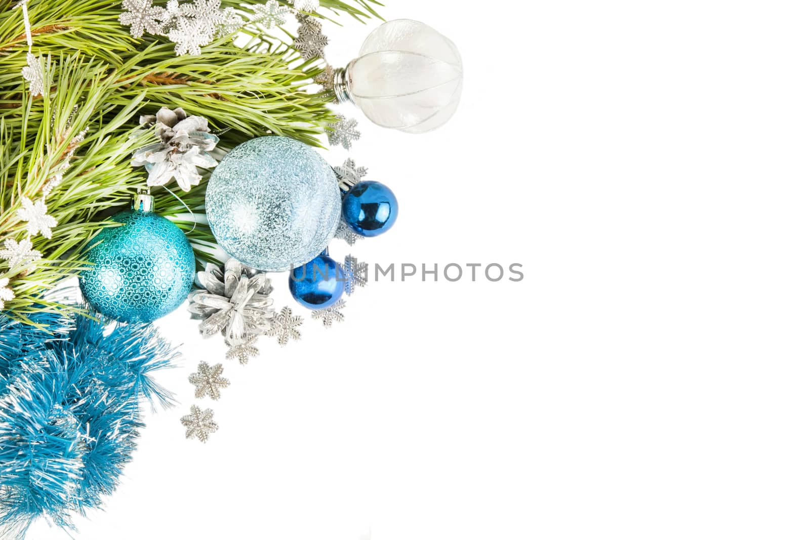 Fir tree branch and cones with blue balls and tinsel isolated on white