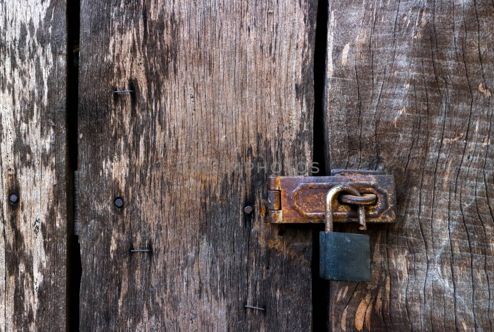 Old master key lock on old wooden background