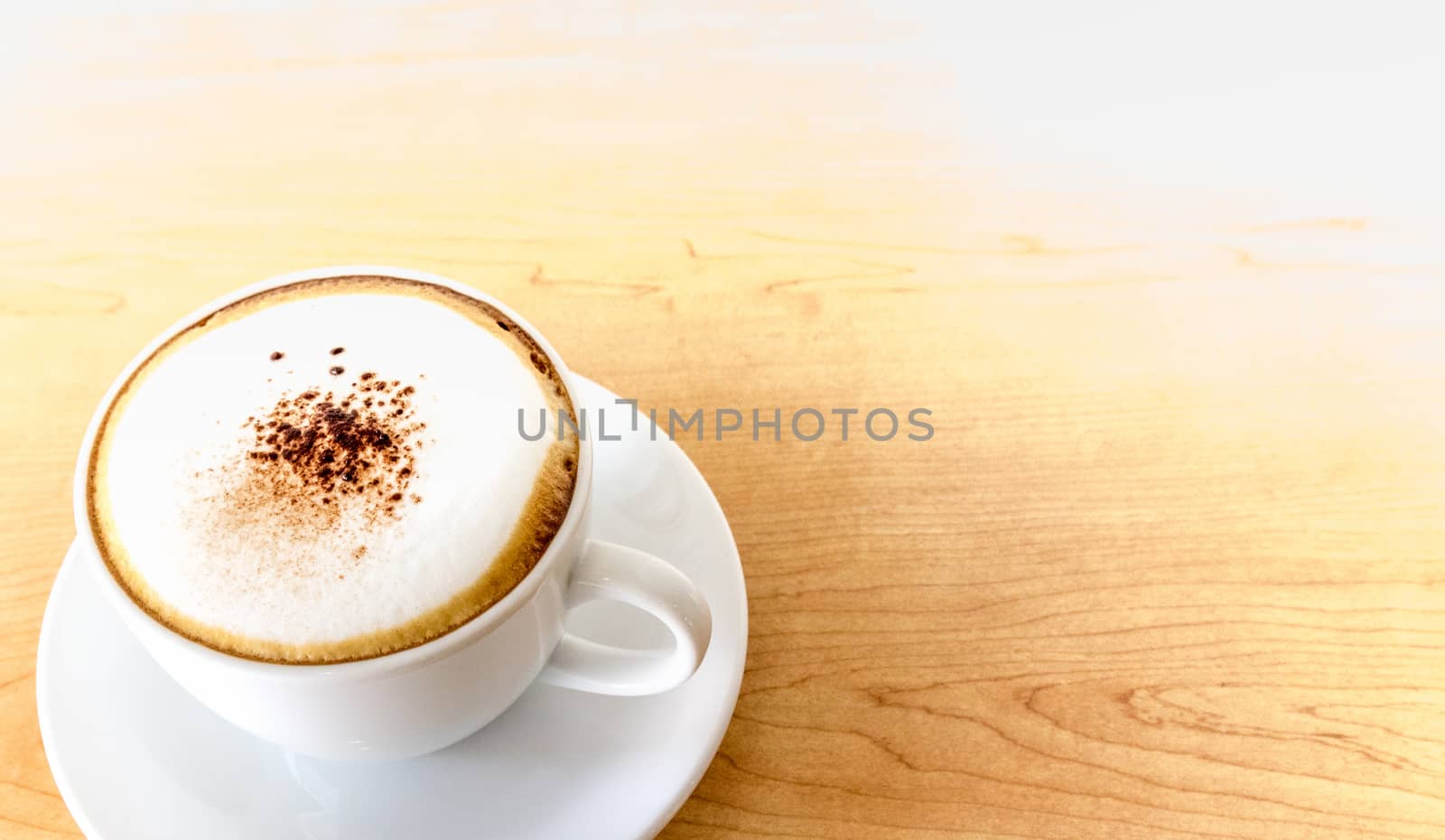 A cup of hot coffee cappuccino on wood table background