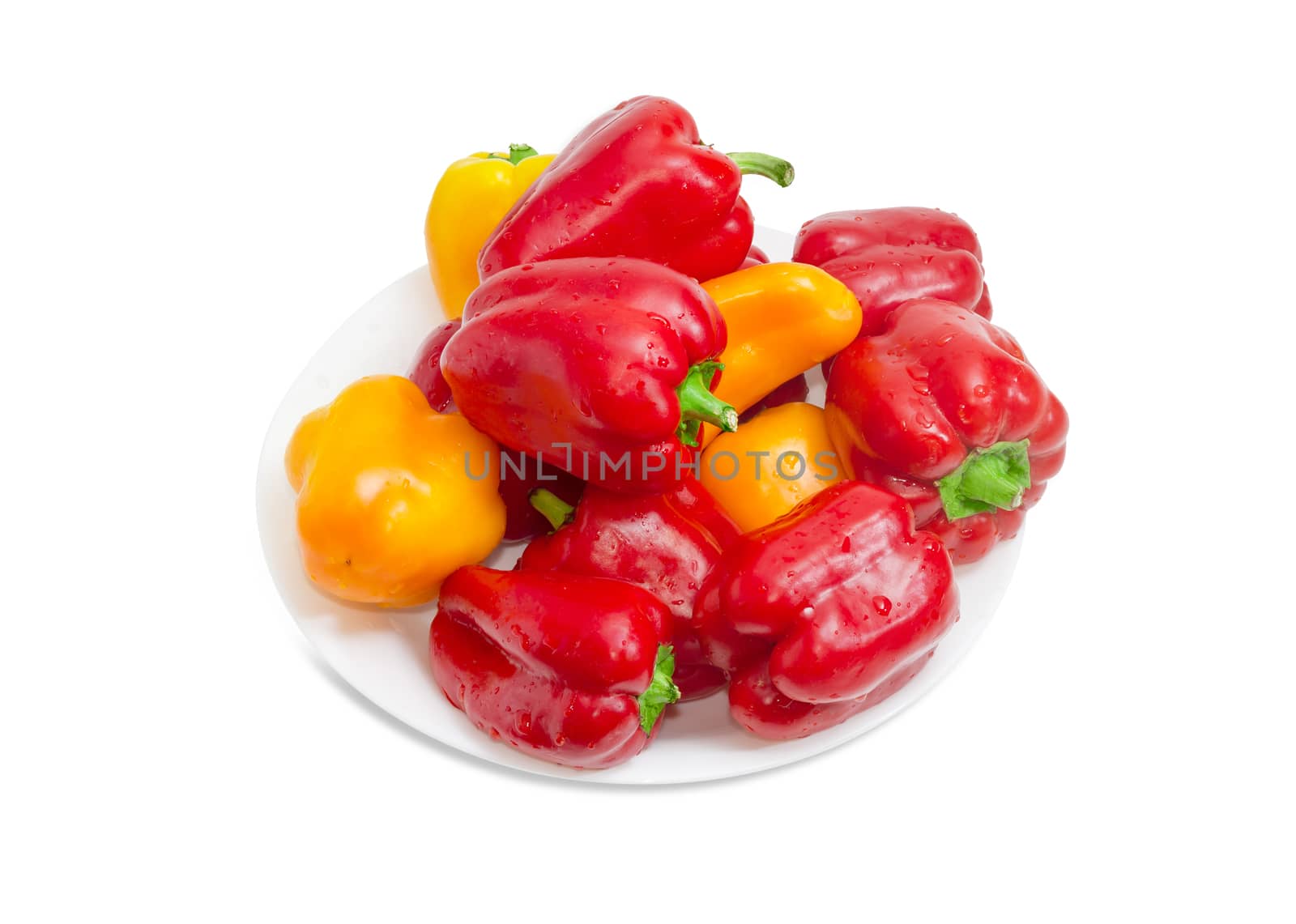 Washed red and yellow bell peppers with water drops on the white dish on a white background
