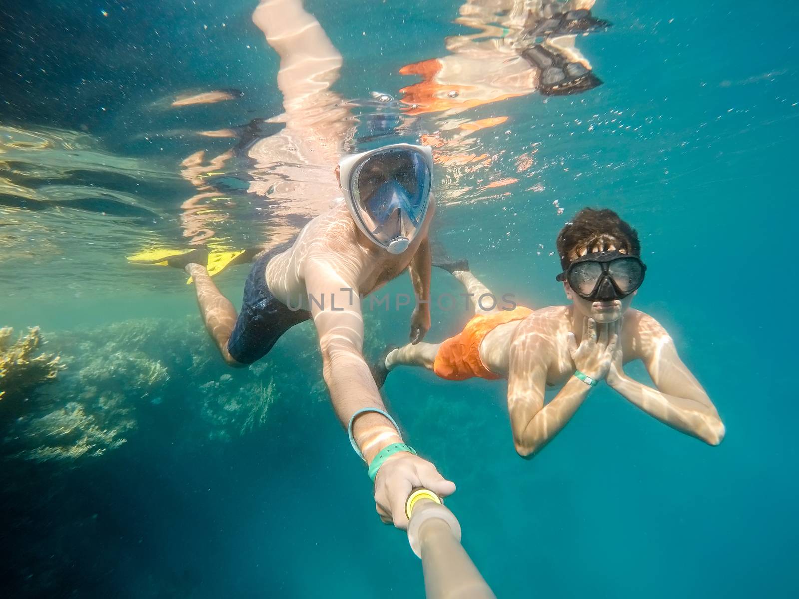 father and son  snorkel in underwater exotic tropics paradise with fish and coral reef, beautiful view of tropical sea. Marsa alam, Egypt. Summer holiday vacation concept