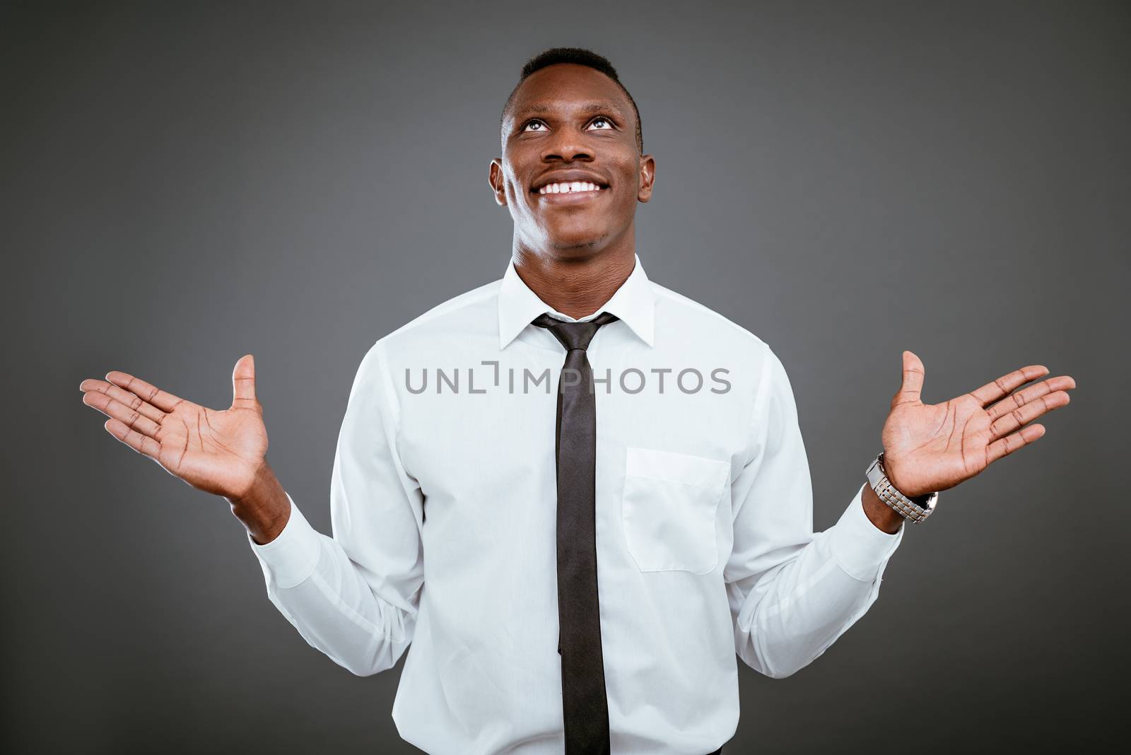 Happiness African businessman celebrating success with raised arms, looking up and praying god.